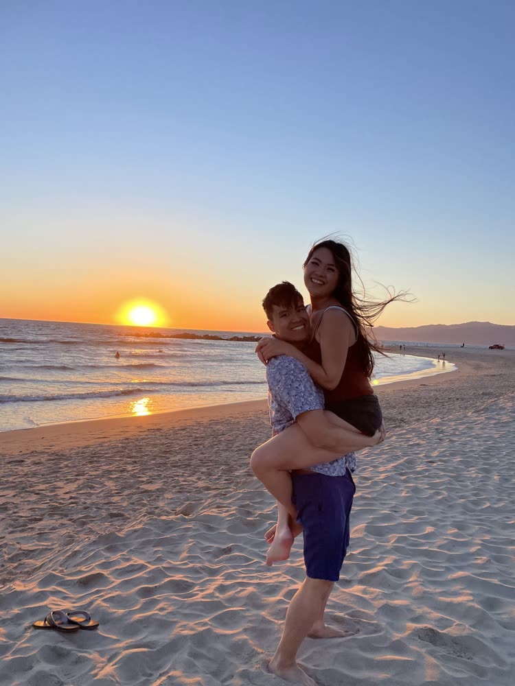 Edward carrying his wife on the beach at sunset