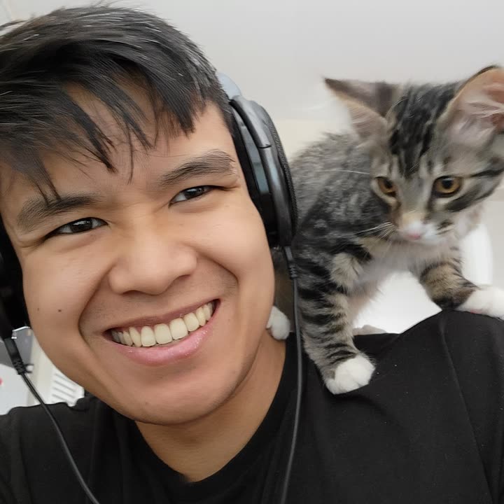 Edward in headphones with a kitten on his shoulder