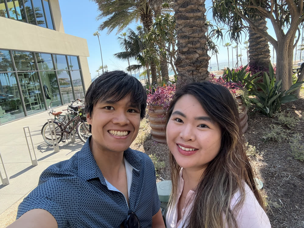 Sunny selfie of Edward and his wife under palm trees